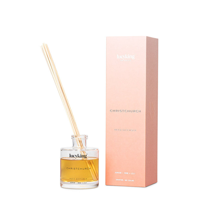 LucyKing CHRISTCHURCH reed diffuser with clear bottle beige reeds and peach packaging on white background